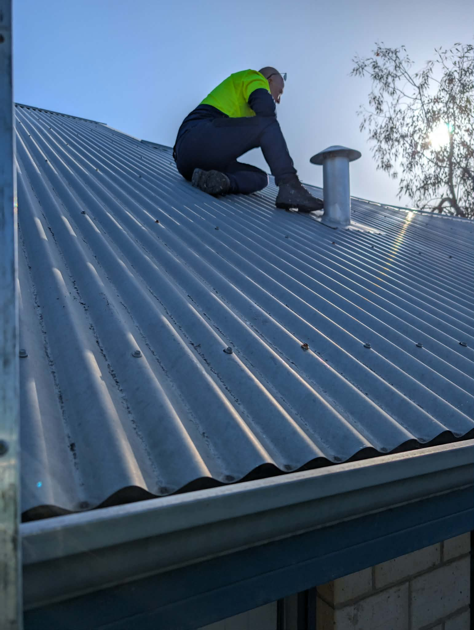 Roofer repairing roof flashing and vent
